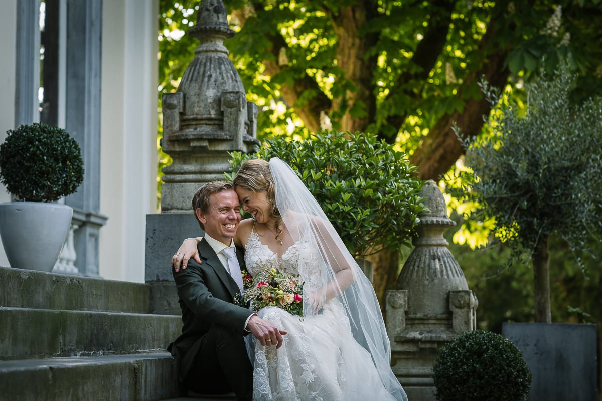 bruidspaar zittend buiten trappen landgoed_wolfslaar kleur trouwfoto natuurlijke authentieke trouwreportage documentair bruidsfotograaf breda