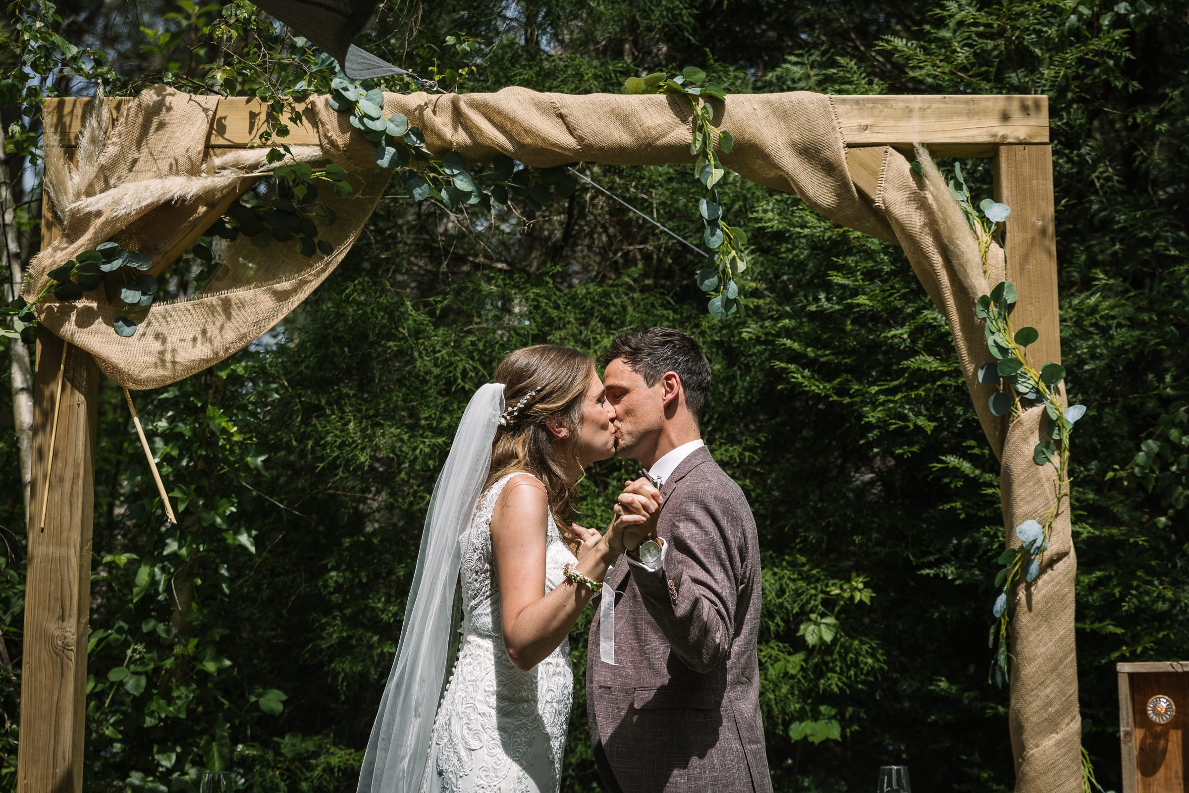 de kus trouwceremonie bruidspaar buiten natuurlijk_de_kloof bergen_op_zoom trouwfoto kleur door documentair bruidsfotograaf Breda natuurlijke authentieke ongepaneerde trouwreportage