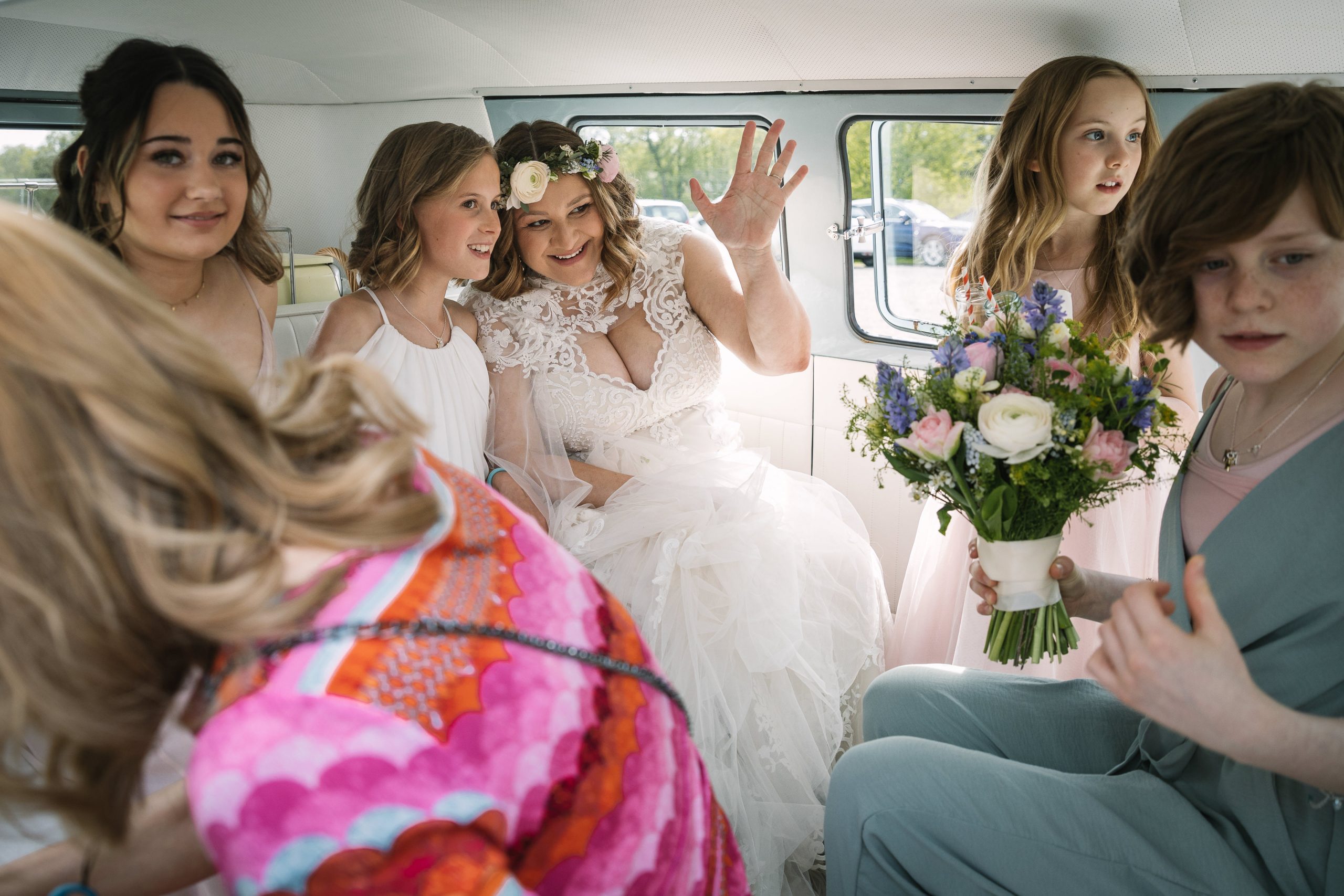 bruid bruidsmeisjes zwaaien trouwauto volkswagen_busje VW natuurlijke ongedwongen documentaire bruidsfotografie breda