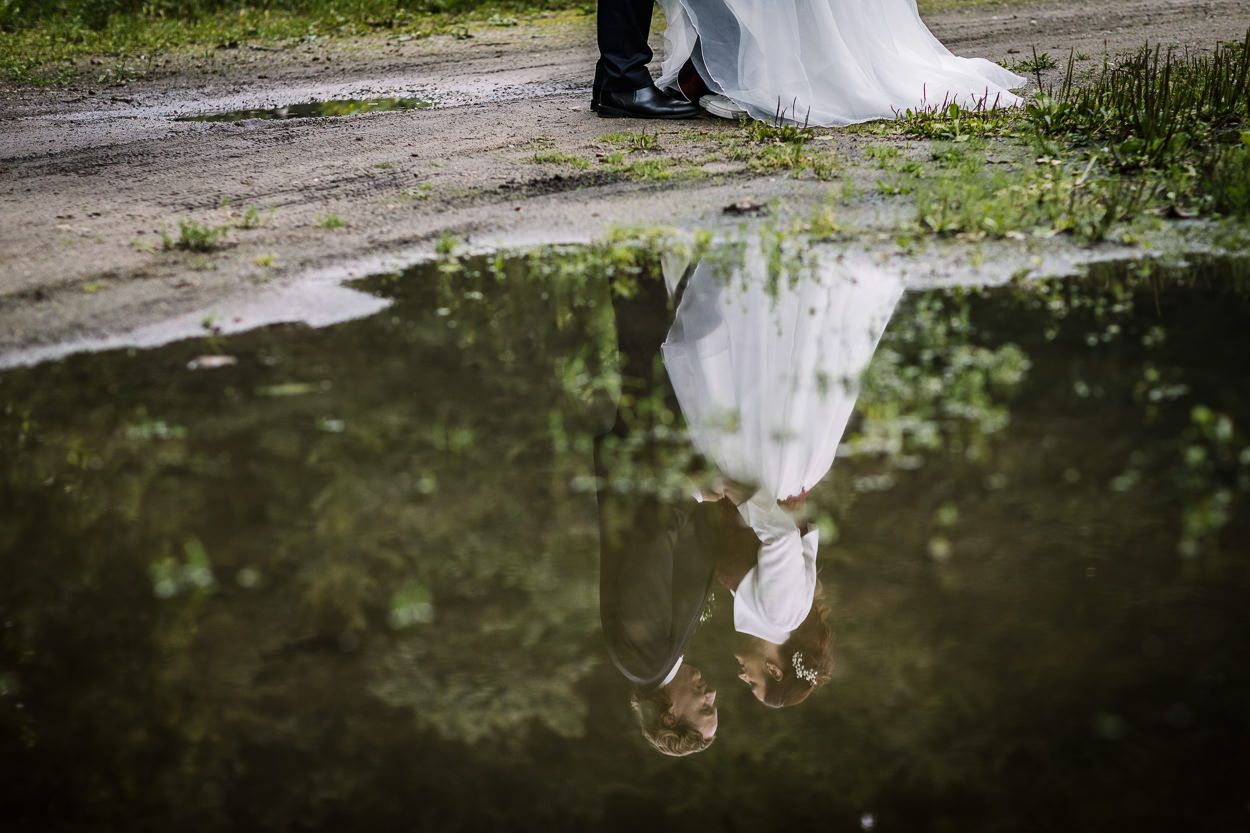 bruidspaar weerspiegelt in plas water tijdens fotoshoot mastbos natuurlijke bruidsfotografie ongedwongen relaxte bruidsfoto door journalistiek trouwfotograaf documentair bruidsfotograaf Breda